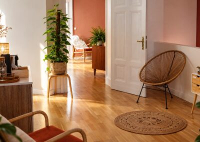 Einladende skandinavisch-böhmische Eingangshalle mit Pflanzen und einem Rattanstuhl bei My International Therapy, Berlin